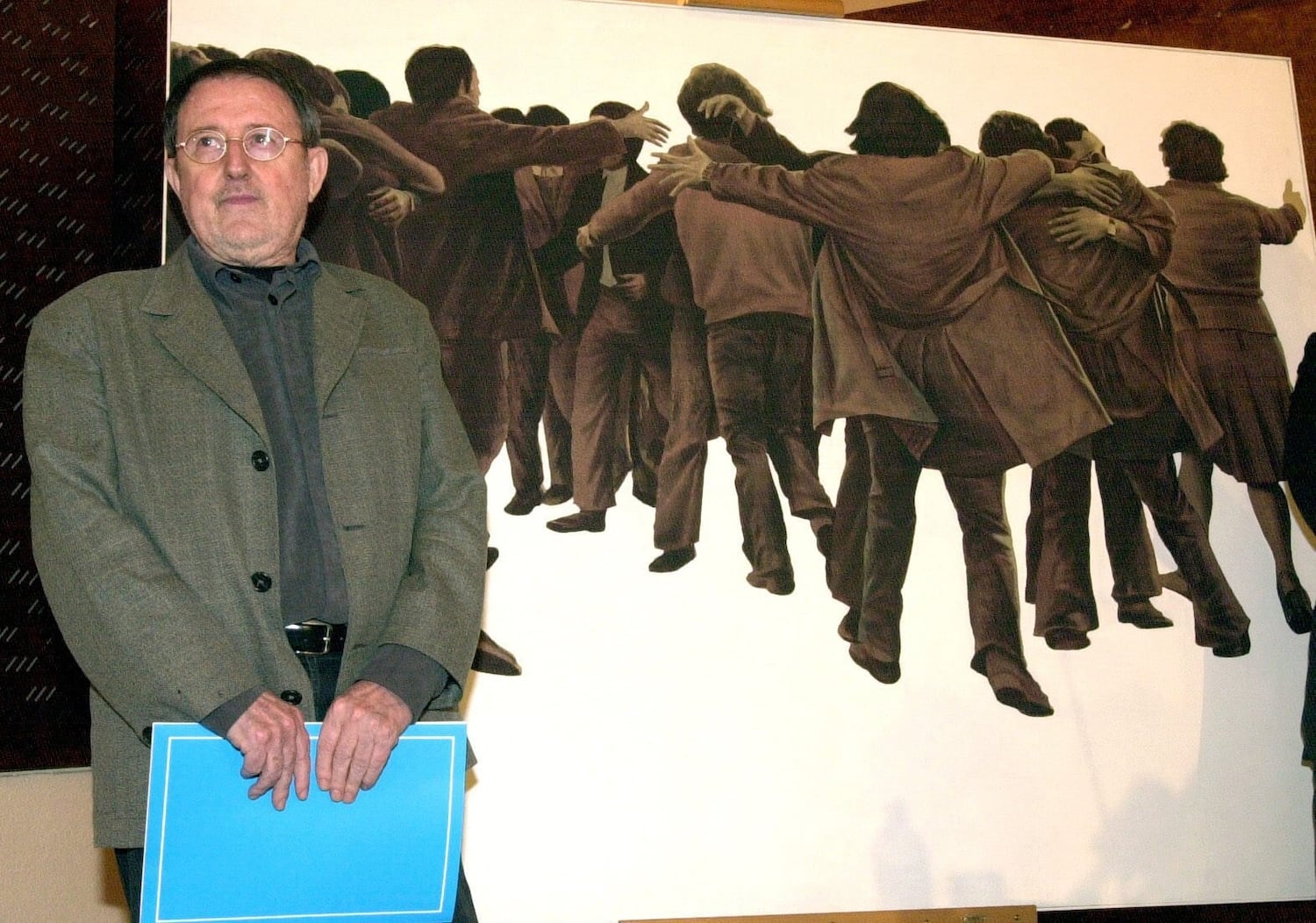 Juan Genovés posando en el Museo Reina Sofía junto a su obra emblemática "El Abrazo".