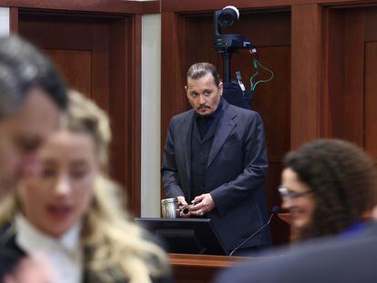 Johnny Depp, el jueves durante el juicio en Fairfax (Virginia). En primer término, Amber Heard habla con Benjamin Rottenborn, uno de sus abogados.