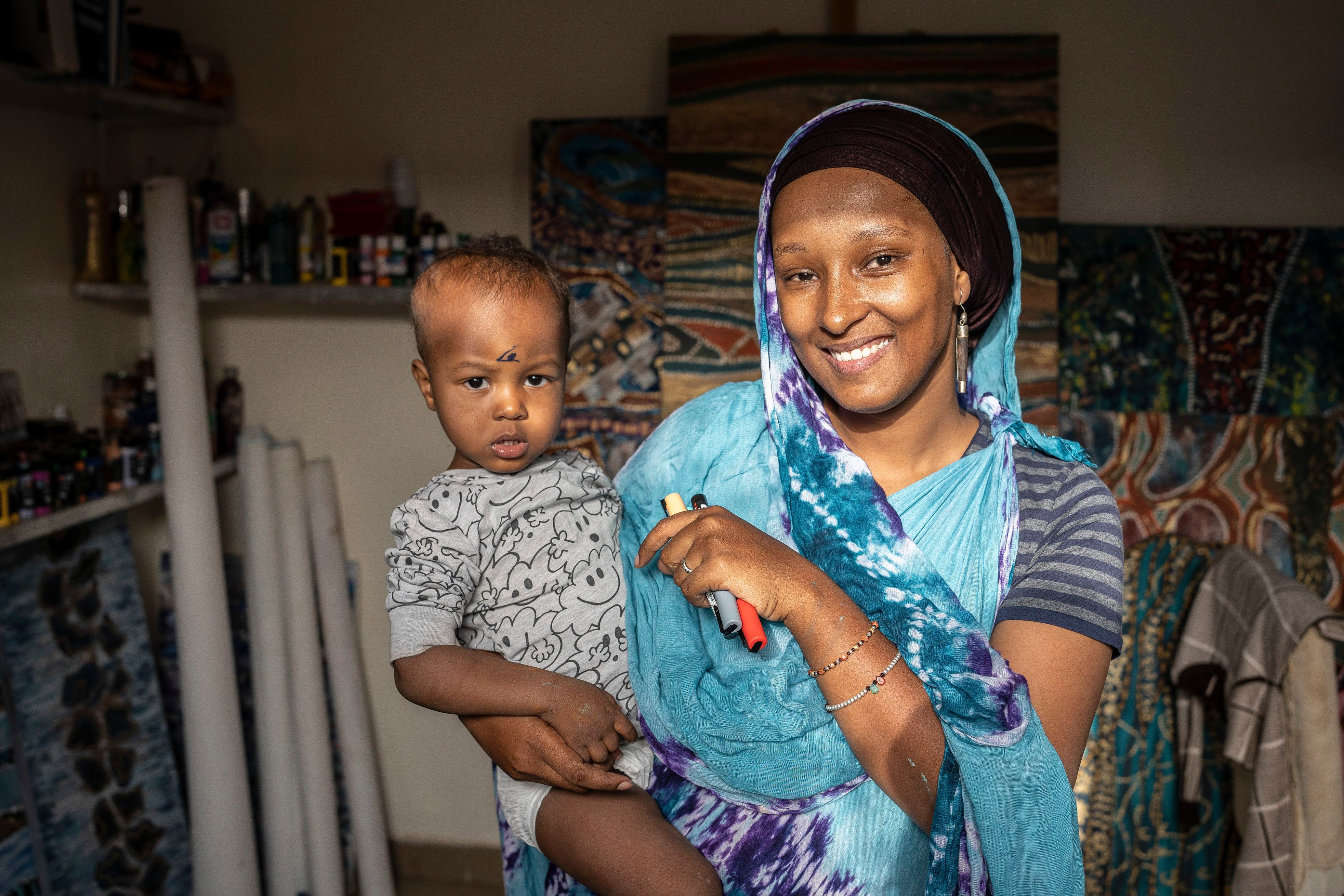 Laila Halidou posa junto a su hijo Yaassine en su estudio de Niamey, donde pasa gran parte de su tiempo compaginando la crianza con la creación artística.