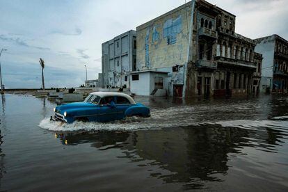 Un viejo automóvil pasa por una calle inundada en La Habana, este miércoles.