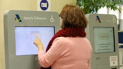Una mujer recoge su turno en una oficina de la Agencia Tributaria en una oficina de Madrid.