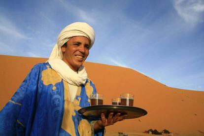 Seg&uacute;n los n&oacute;madas del S&aacute;hara el t&eacute; se disfruta en tres vasos, &ldquo;el primero es fuerte como el amor, el segundo amarga como la vida, y el tercero dulce como la muerte&rdquo;.  En la imagen, un beduino sirve t&eacute; en el Erg Chebbi de Merzouga, Marruecos. 