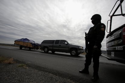 Un policía estatal de Nuevo León custodia la carretera ante la llegada de visitantes.