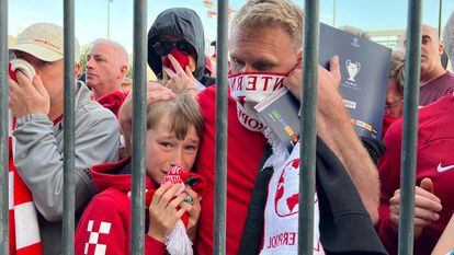 Un padre consuela a su hijo, retenidos a las puertas del estadio.