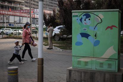 Una mujer y un niño caminan por una calle de Pekín este miércoles