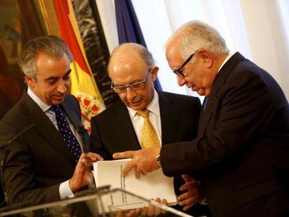 Montoro recibe el informe de manos de Lagares, derecha, junto con el Secretario de Estado Miguel Ferre.
