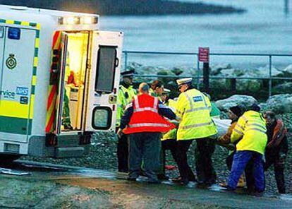 Los servicios de rescate introducen un cuerpo en una ambulancia en la bahía de Morecambe.