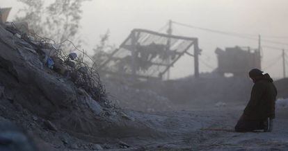 Un trabajador palestino ora, este jueves, en una compa&ntilde;&iacute;a que recicla escombros de casas destruidas en material reutilizable para construcci&oacute;n, en la Franja de Gaza. 