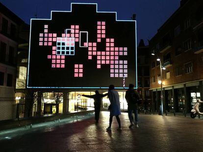 Varias personas interactúan con el videojuego "Rompecabezas humano" en la Plaza de las Letras, en Madrid.