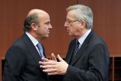 El ministro de Economía, Luis de Guindos, escucha al presidente del Eurogrupo, Jean-Claude Juncker