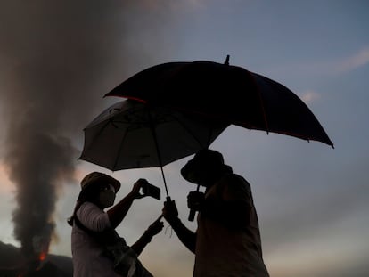 Una pareja se protege de las cenizas del volcán Cumbre Vieja en la mañana de este lunes.