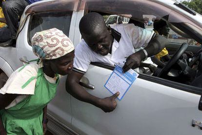 Un hombre explica a una mujer joven en Juba el método para votar en el referéndum de autodeterminación de Sudán del Sur.