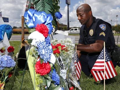 Un polic&iacute;a de Baton Rouge rinde homenaje a los agentes asesinados en el lugar del atentado, el lunes.   