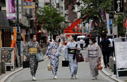 Unas mujeres pasean en Tokio con el traje tradicional de 'geisha', en julio.