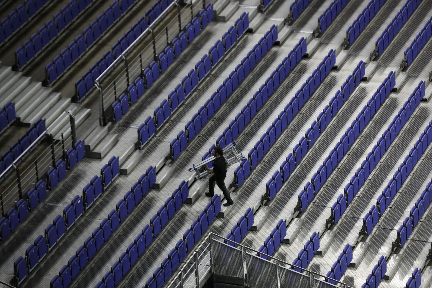 Miembros del staff caminan por la gradas e instalaciones del WiZink Center de Madrid.