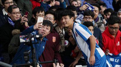 Wu Lei, del Espanyol, posa con aficionados en Barcelona.