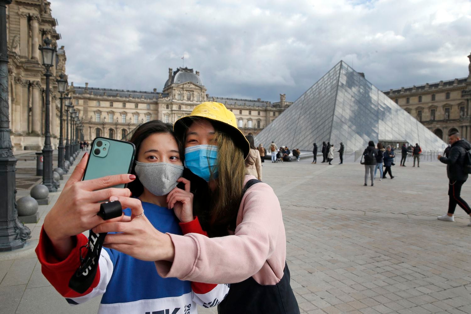 Dos mujeres con máscara protectora ante el Museo del Louvre en París, el 6 de marzo