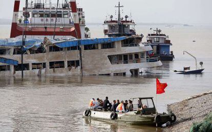 Trabajadores sobre el barco naufragado tras lograr enderezarlo.