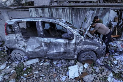 Dos hombres inspeccionaban este lunes un vehículo destrozado tras un bombardeo israelí, en el campo de refugiados de Rafah, en la franja de Gaza. 