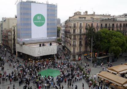 Una gran pancarta y un abanico verde en el suelo en la protesta de los arquitectos