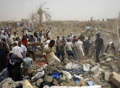 Varios iraquíes rebuscan entre las ruinas del camión bomba que explotó ayer en Kirkuk.