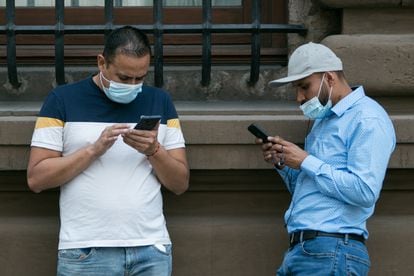 Dos hombres utilizan sus teléfonos móviles en el centro de Ciudad de México.