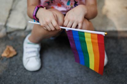 Una niña sostiene la bandera del arcoiris minutos antes del inicio de una manifestación por el Orgullo LGTBIQ+