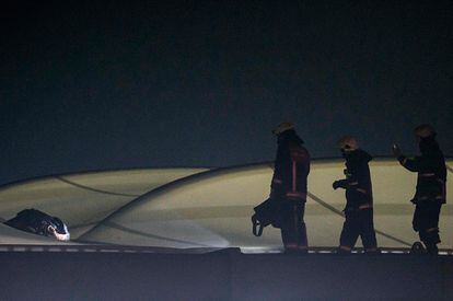 Los bomberos junto un cuerpo en el techo del estadio Vodafone Arena en Estambul, tras la explosión de un coche bomba.