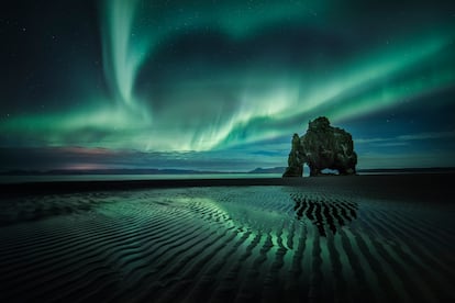 El legendario farallón de Hvitserkur a la luz de una aurora boreal.
