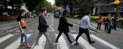 Cuatro émulos de los Beatles cruzando ayer el paso de cebra de Abbey Road, en Londres, ante el objetivo de los fotógrafos amateurs.