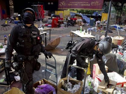 Dos policías rebuscan entre cajas tras acceder el jueves a la Politécnica de Hong Kong.