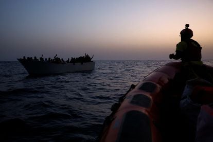 Migrantes dan señales al bote de rescate de la ONG Proactiva Open Arms desde una patera, en el Mediterráneo central, a mediados de agosto. 