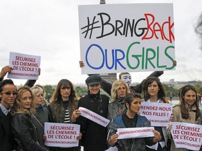 Actrices y modelos francesas posan frente a la Torre Eiffel con pancartas para mostrar su apoyo a la liberación de las niñas secuestradas en Nigeria.
