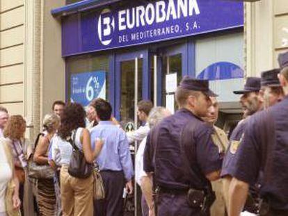 Clientes del Banco Eurobank del Mediterráneo hacen cola en una sucursal en Barcelona para intentar recuperar su dinero e informarse de la situacion de la entidad financiera intervenida por el Banco de España a petición propia por sus problemas patrimoniales. EFE/Archivo