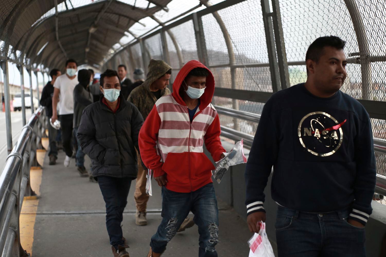 Migrantes centroamericanos usan mascarillas protectoras al cruzar la frontera entre México y Estados Unidos, el pasado 21 de marzo.