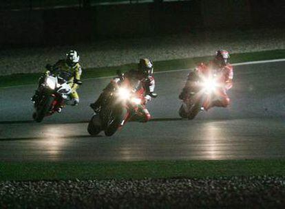 De izquierda a derecha, Rossi, Capirossi y Roberts durante una exhibición nocturna en Qatar, en abril de 2006.