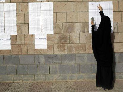 Una mujer revisa una lista electoral en un colegio de San&aacute;. 