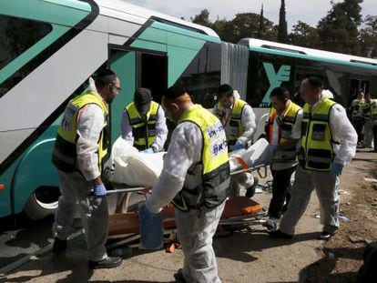 Treballadors sanitaris transporten el cos d'una víctima mortal en l'atac en un autobús a Jerusalem Est.