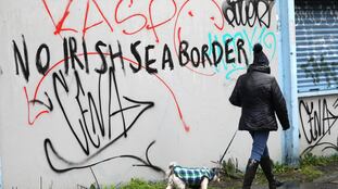 Una mujer camina frente a una pared en la que se lee "Sin frontera del mar de Irlanda", en Belfast el miércoles.