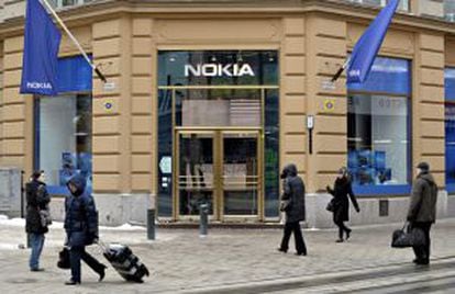 Varios viandantes pasan delante de una tienda que la fabricante de teléfonos móviles Nokia tiene en Helsinki (Finlandia).
