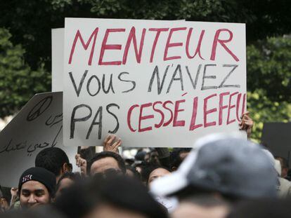 Un ciudadano sostiene una pancarta durante la protesta donde se puede leer "Menteur, vous n'avez pas cessé lefeu" ("Mentiroso, usted no paró el fuego").