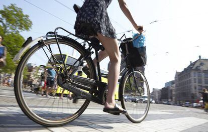 Mujer pedaleando en Ámsterdam, en Países Bajos.