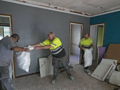 De izquierda a derecha, Vicente, Juan y Francisco, trabajan en la rehabilitación de un piso para uso social.