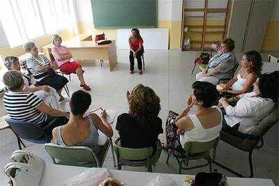 Las mujeres que participan en la terapia de grupo para <i>elaborar</i> duelos, sentadas frente a la psicóloga en Guadarrama (Madrid). ULY MARTÍN