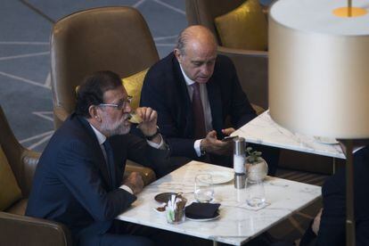 El entonces presidente del Gobierno, Mariano Rajoy, acompañado por el ministro del Interior en funciones, Jorge Fernández Díaz, en junio de 2016 en Barcelona.