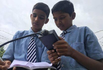 Vamshi Voggu y Gurulingam Goud, apuntan los registros de la estación meteorológica instalada en su colegio.