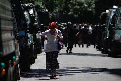 Una mujer camina por las calles de Buenos Aires mientras gendarmes y manifestantes se enfrentan en una protesta contra la cumbre del G-20, en noviembre de 2018. 