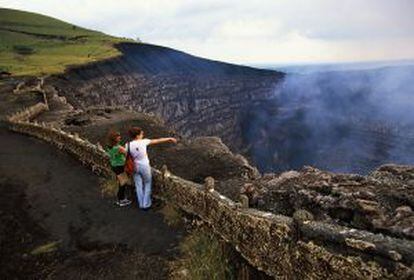 Dos turistas frente a 'Santiago', el humeante cráter del volcán Masaya, en Nicaragua.