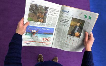 Un lector de El País con un ejemplar del periódico.