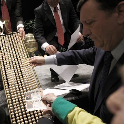 El Gordo del año pasado dejó 80 millones en un pequeño pueblo de la sierra de Cádiz. En la imagen, algunos de los asistentes al sorteo de Navidad de la Lotería Nacional de 2014 comprueban que sus números esten entre las bolas antes de echarlas al bombo en el Teatro Real de Madrid.